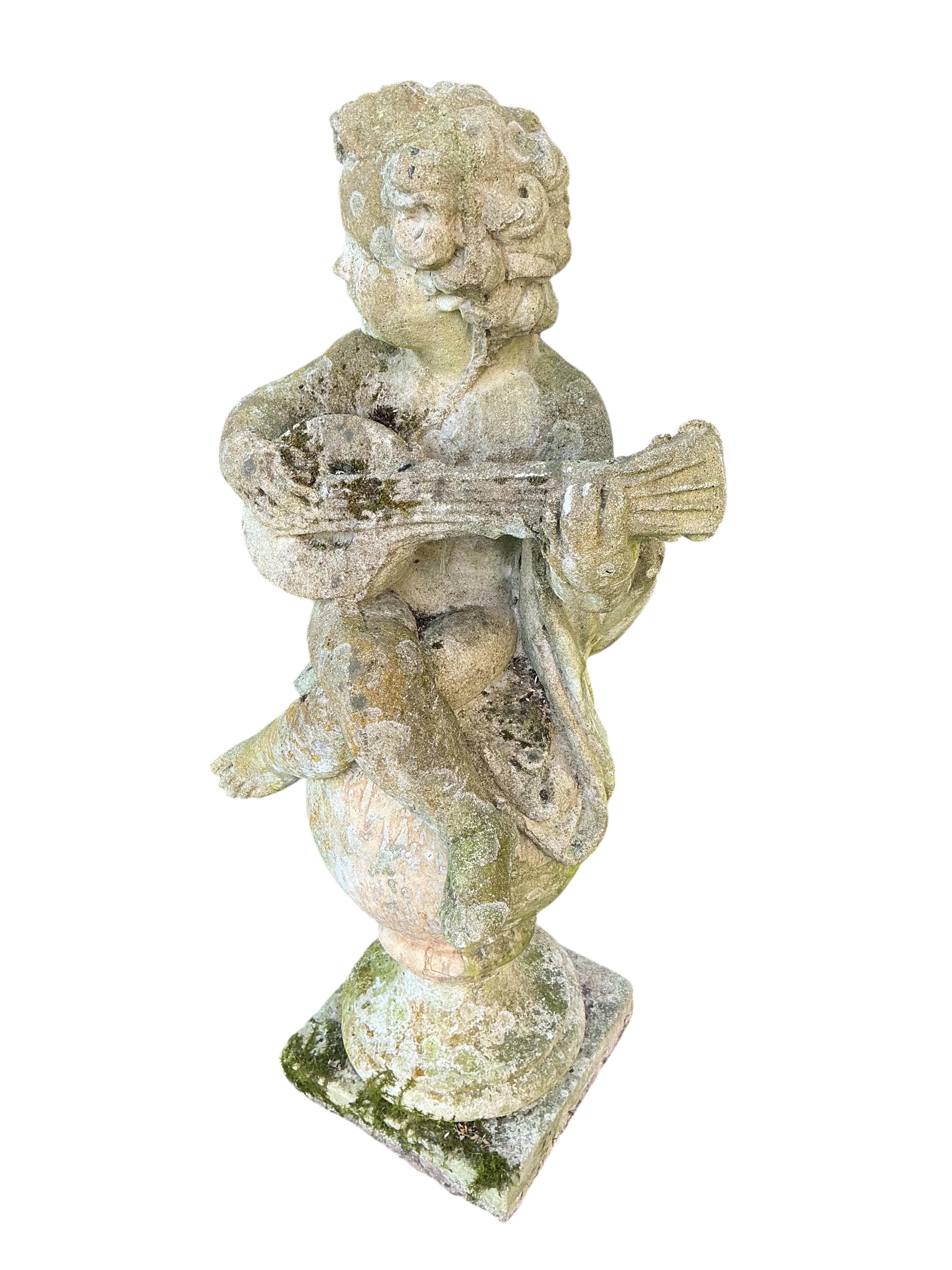 A reconstituted stone musical cherub garden ornament, height 100cm